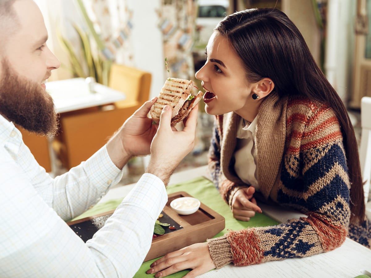 man feeding woman
